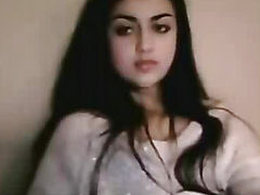 Beautiful Indian woman with long black hair in her robe sitting on a bed